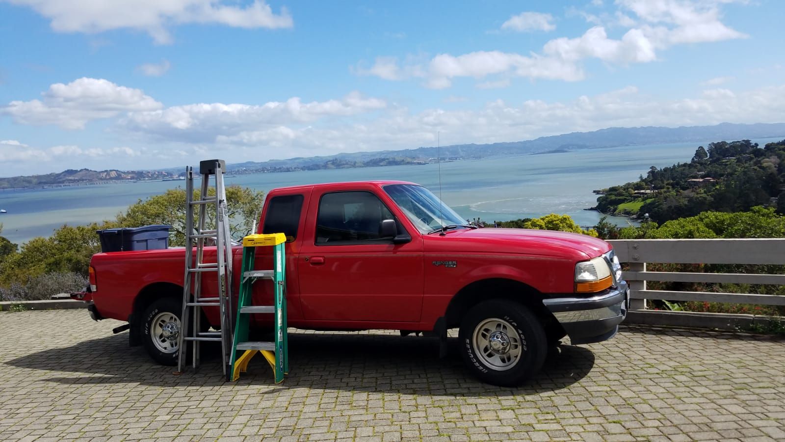 Clean and Sparkle truck loaded with ladders, parked above San Francisco Bay